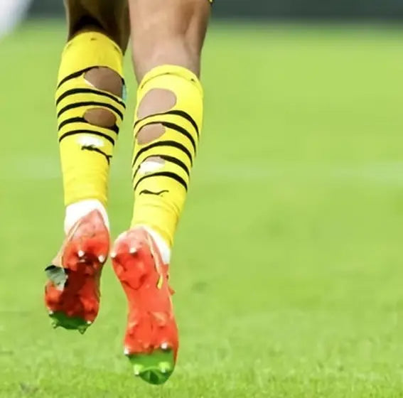 Matchday photo: footballer wearing socks with holes cut at the calf (case 13)