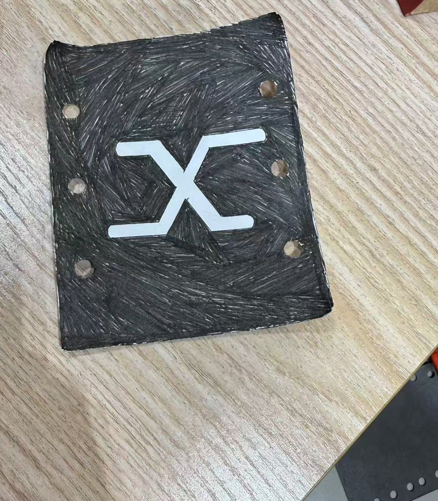 Hand-drawn first draft of the PITCH X mark on a wooden desk